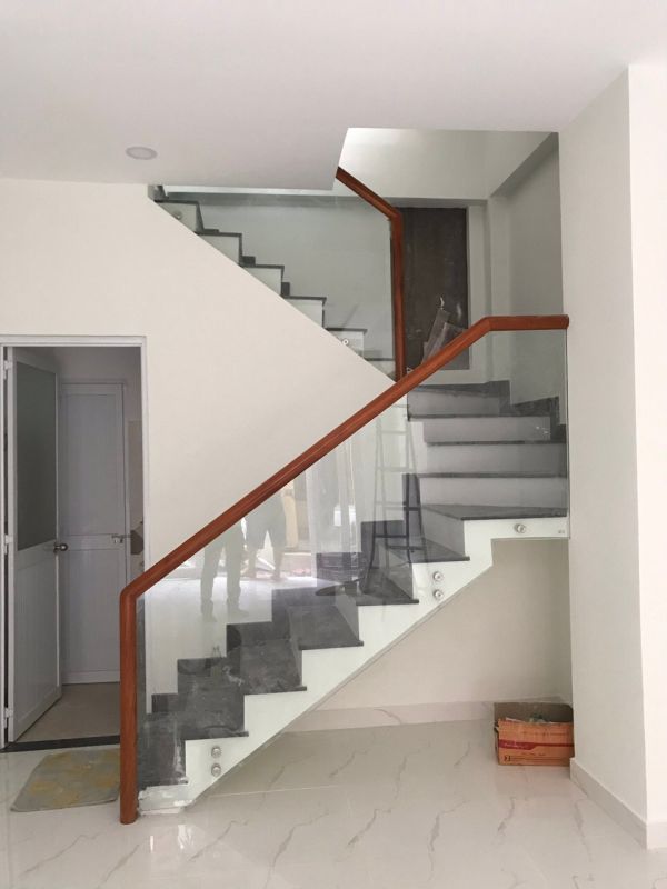 Mẫu cầu thang kính tay vịn gỗ đẹp tại TPHCM